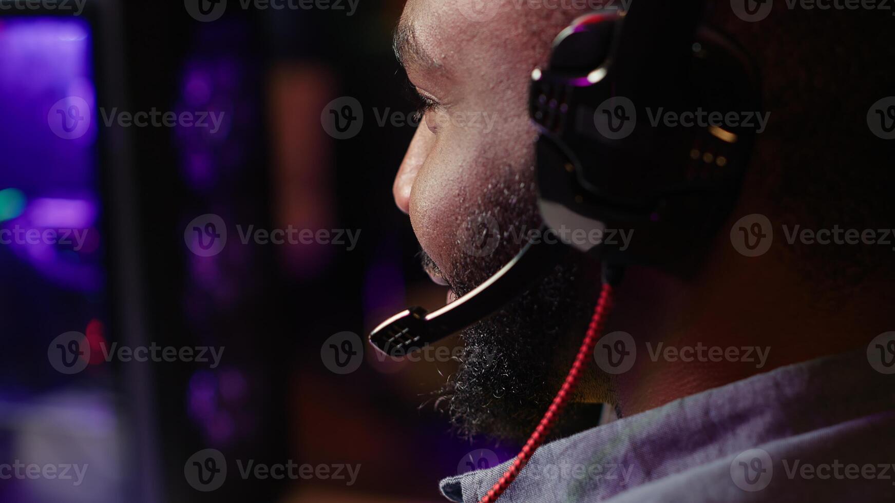 Close up of pro streamer streaming videogame on powerful computer during online gaming championship, talking into headset. Gamer taking part in Esport team of gamers, competing in game, camera A photo