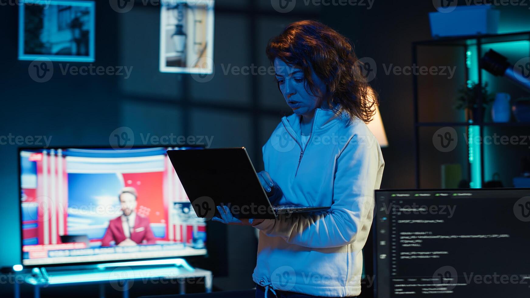 Woman walking in apartment designing and developing software applications using laptop. IT professional standing in living room, implementing and maintaining company systems, camera A photo