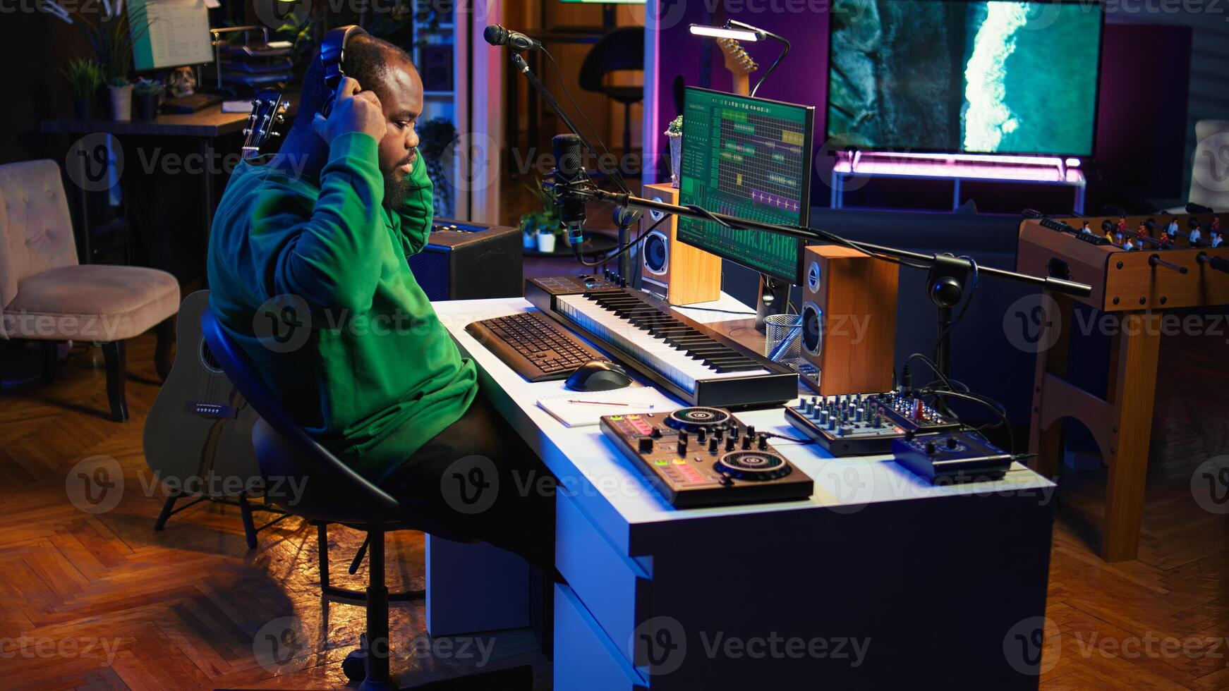 Artist composer recording a new track on his home studio microphone, editing his song with professional gear. Adjusting volume levels and adding sound effects, mix and master. Camera B. photo