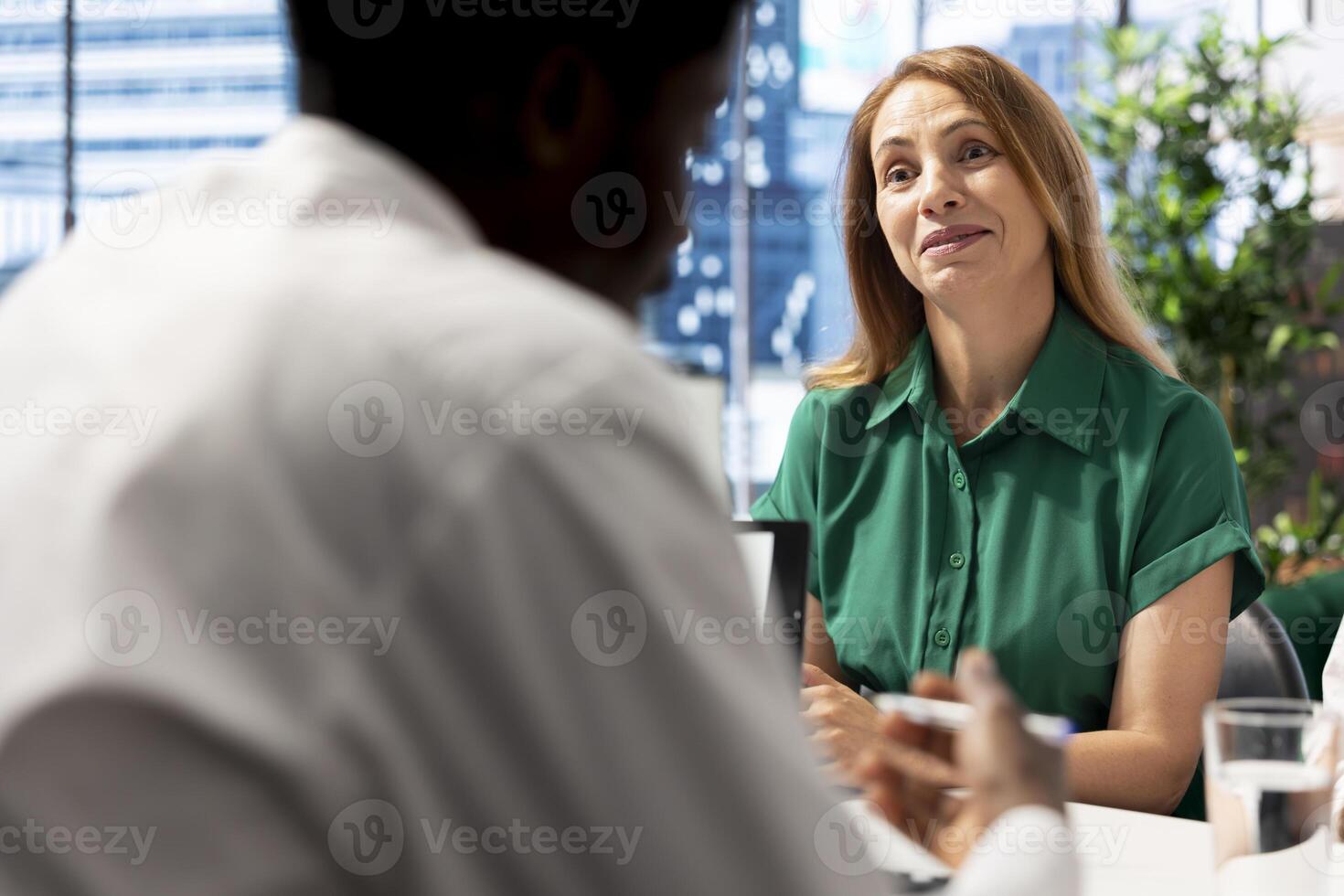 Smiling HR worker interviewing person after doing background checks to job applicant. Cheerful human resources department expert chatting with candidate for vacant startup business position photo