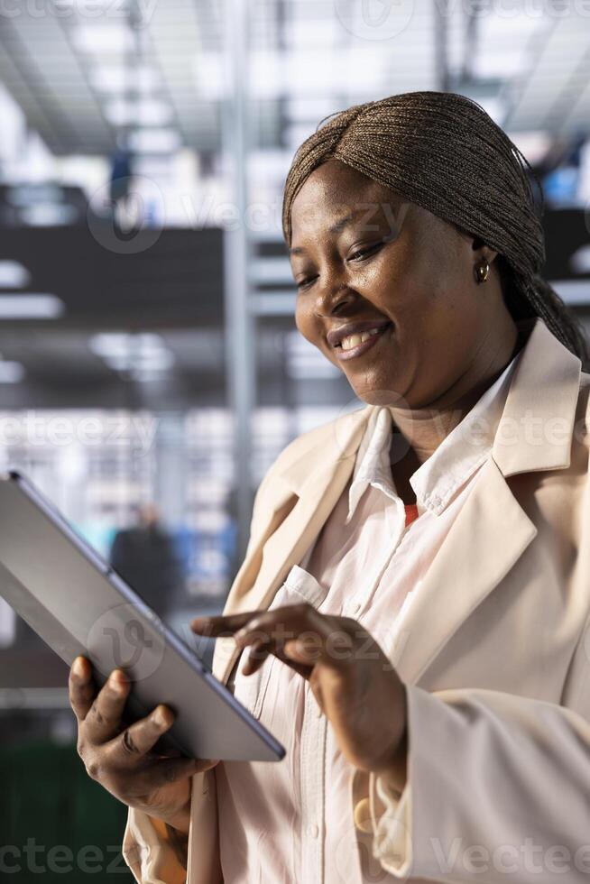 Happy CEO satisfied after looking over business revenue charts and diagrams on tablet in office. Cheerful manager analyzing financial statistics on electronic device, trying to find strategic insights photo