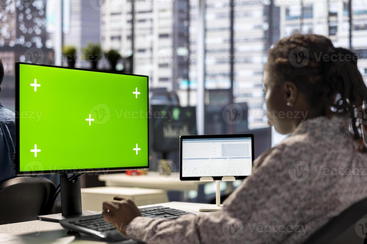 Female executive seated at her workstation with isolated copy space multitasking, analyzing financial reports to support strategic business goals and decision making processes. photo