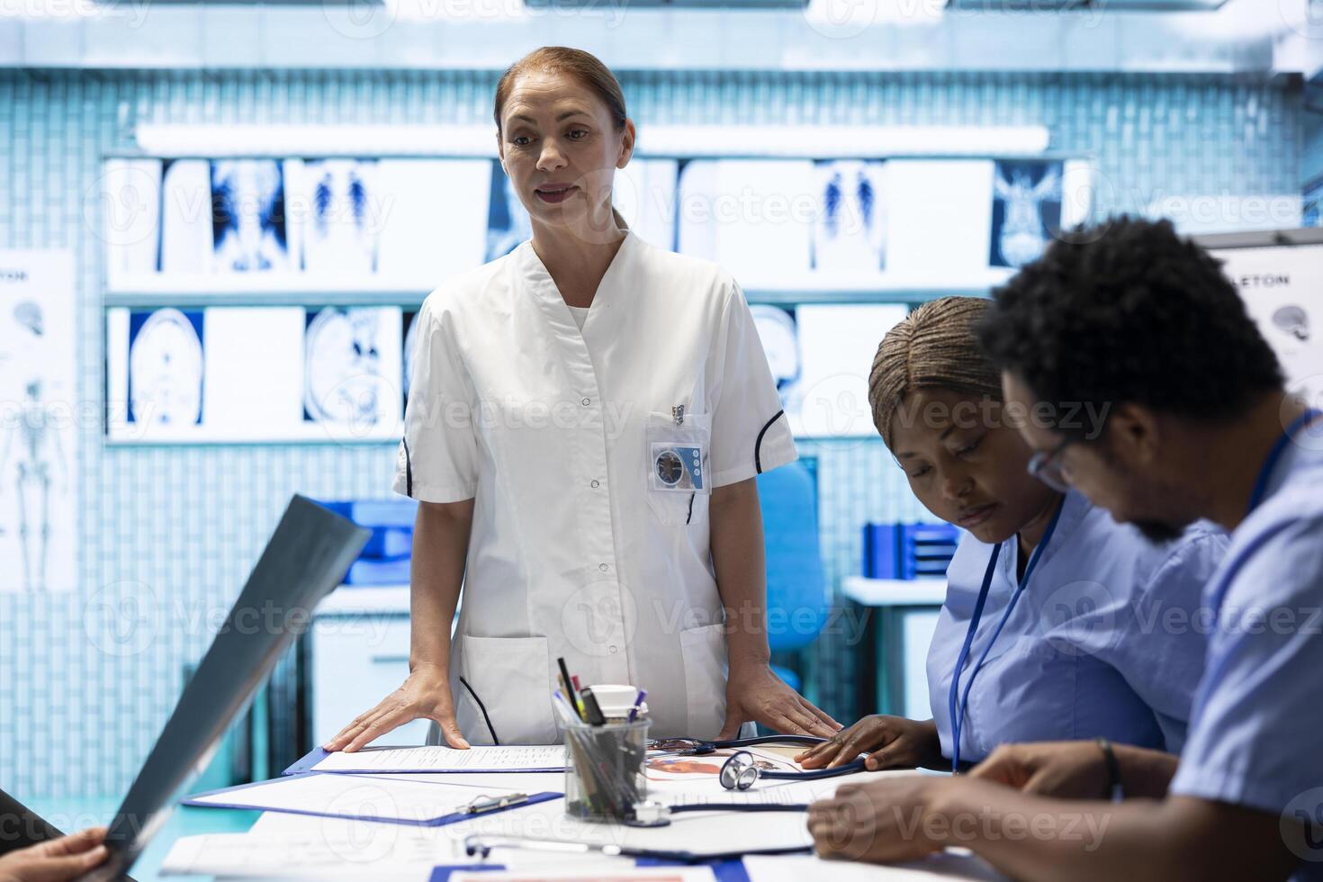 Medical team analyzing diagnostic x rays in a healthcare clinic, focusing on disease prevention and early detection to provide the best treatment care. Licensed doctors consulting test results. photo