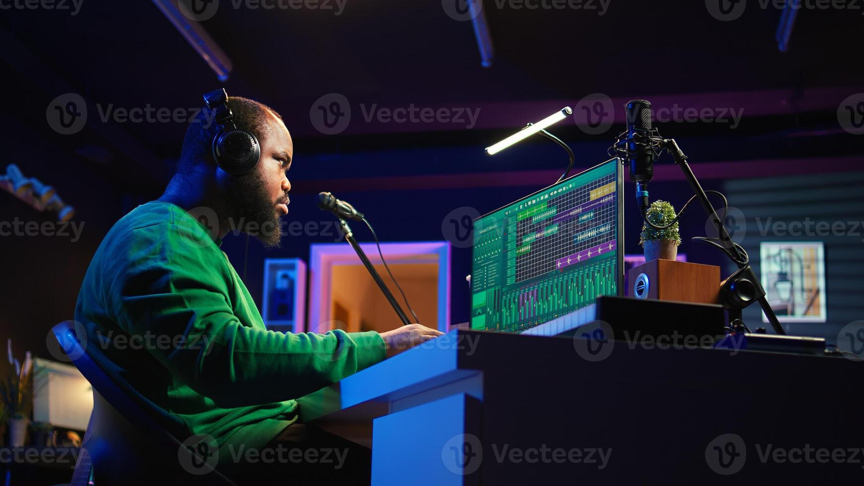 African american music producer twisting knobs on mixing console, produce tracks with sound effects. Artist composing songs in post production, operates on digital software in home studio. Camera B. photo