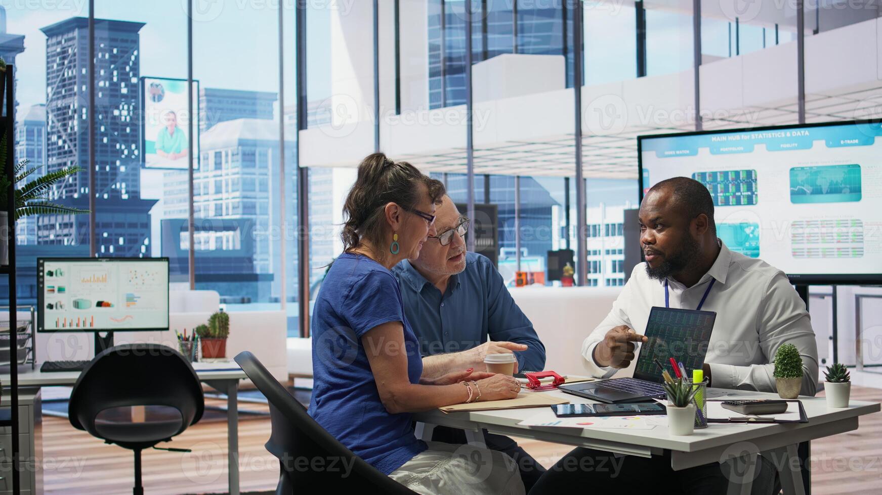 Insurance adviser explaining retirement plans to mature people in a modern office, offering financial advice and counseling for pension options. Investment strategy to secure savings. Camera B. photo