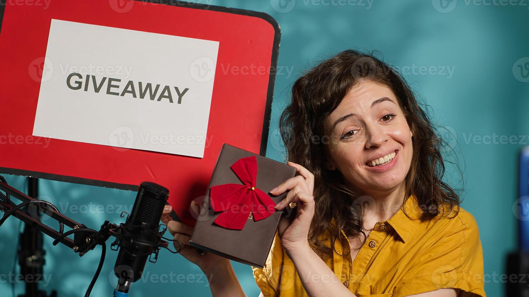 Cheerful content creator holding empty copy space sign, excited to do giveaway for fans. Viral internet star offering packed gift during promotion to gain followers, holding cutout, camera A photo