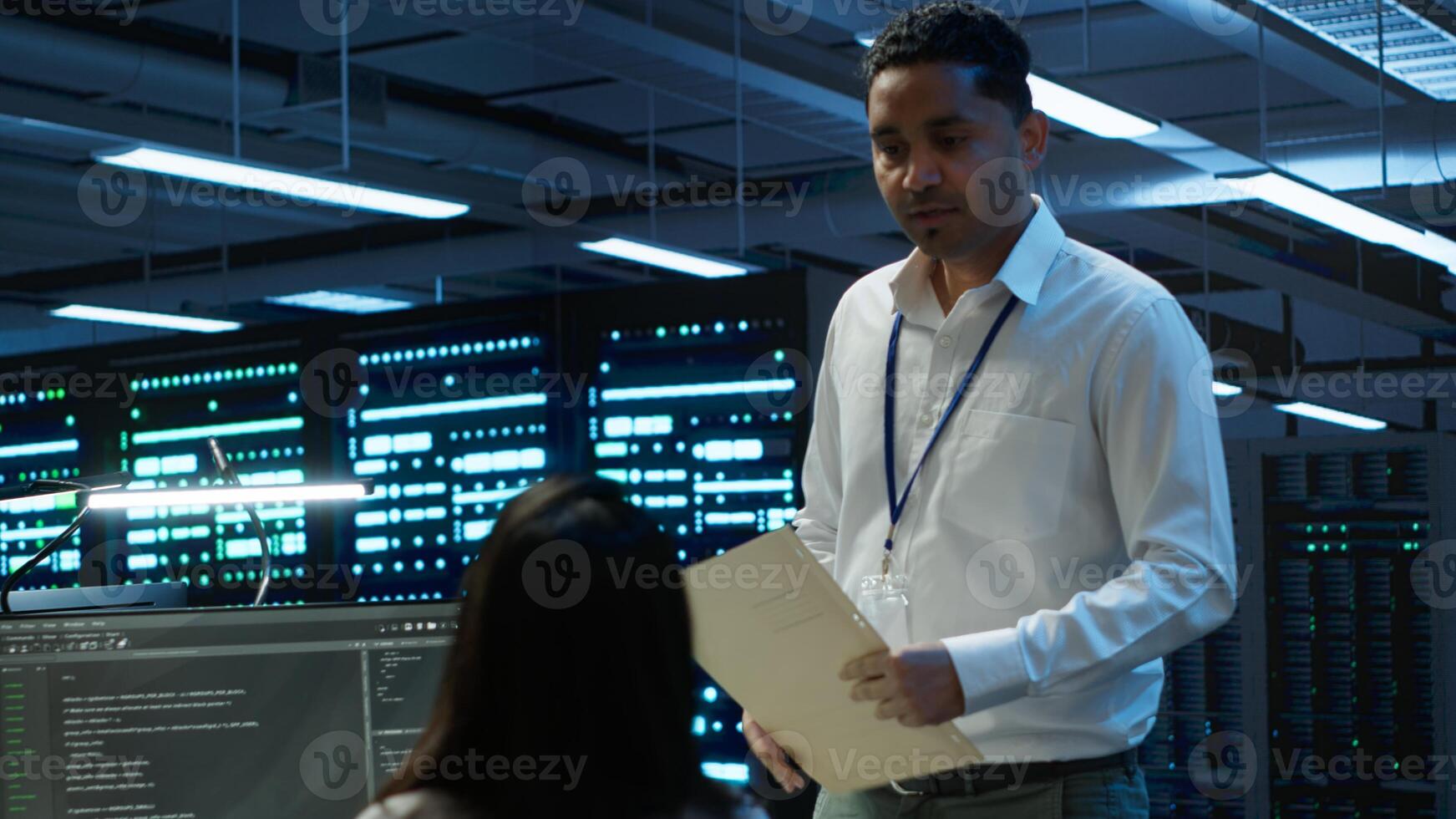 Management executive in data center ensuring system can handle networking tasks. Coworkers doing brainstorming in server room, tracking network traffic with PC, making improvements, camera A photo