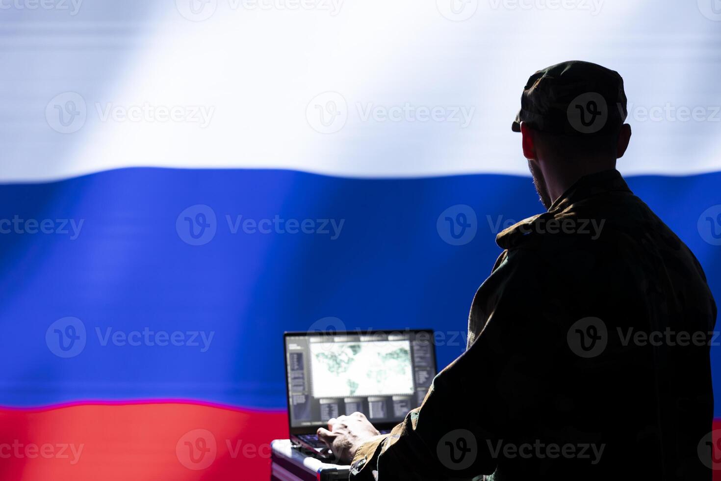 Russian federal security service operative engaged in surveillance mission using laptop, looking at world map. Russia military officer working for Kremlin regime monitoring zone of interest photo