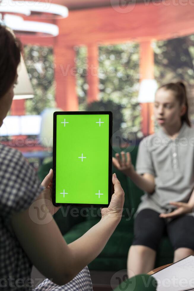 Therapist uses green screen display in a counseling session with an adolescent dealing with low confidence. Psychotherapist supports her in building resilience and self esteem. photo