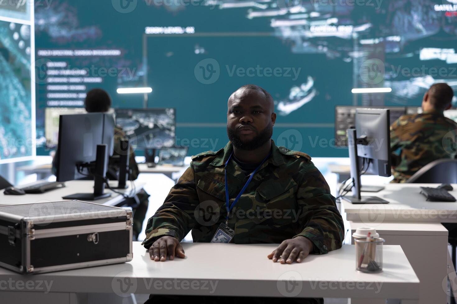 Military officer participates in a secure videoconference call in modern command center, transmitting live satellite information. Federal collaboration for national security operations. photo