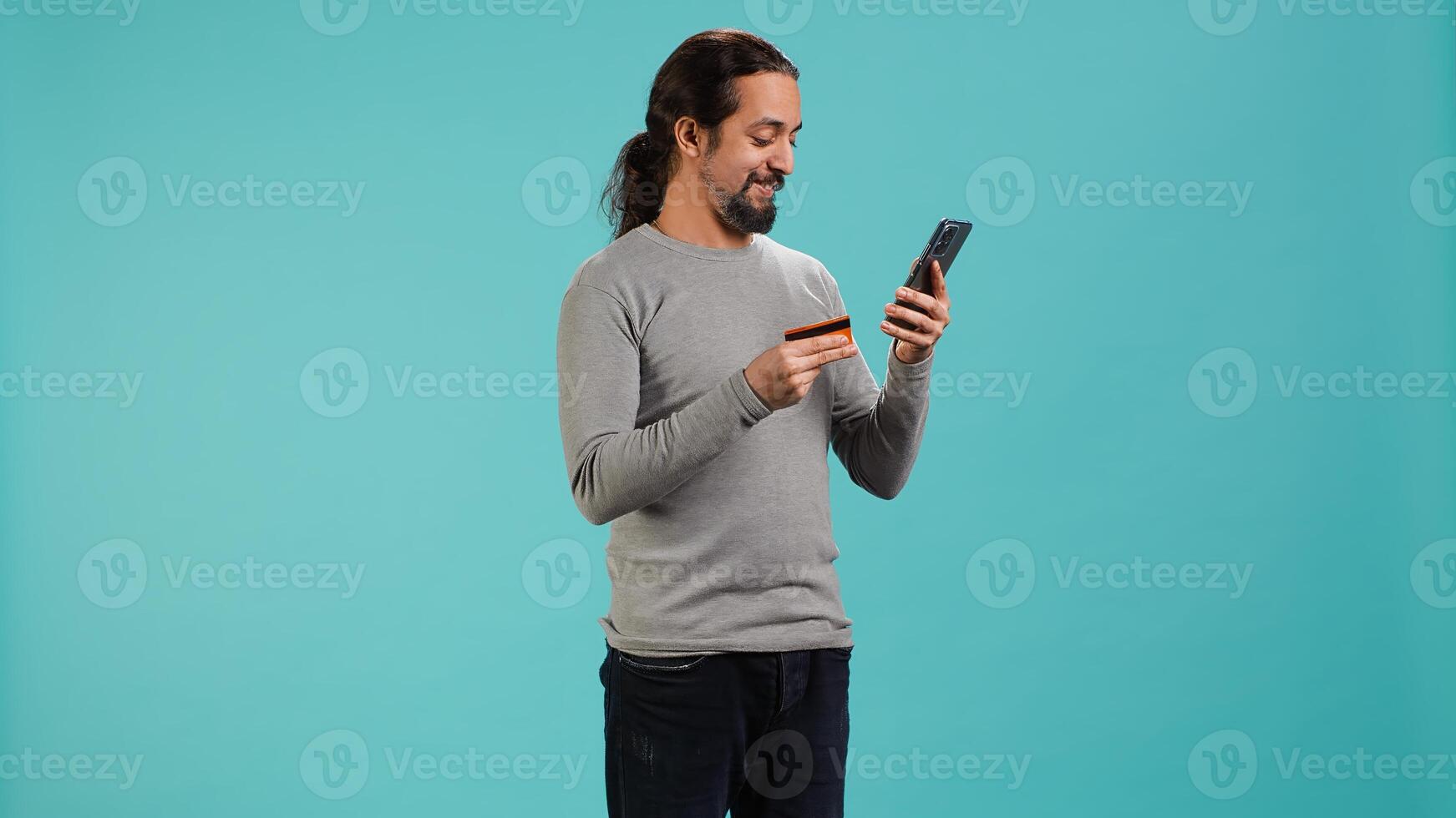 Man adding payment method on website, isolated over blue studio background. Cheerful person excited to do online shopping, carefully typing credit card information, camera A photo