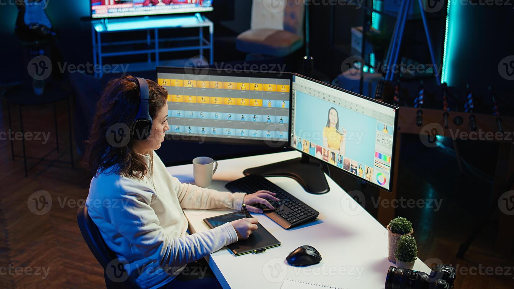 Photo editor using graphic tablet to edit images lighting, delivering visually appealing final product, listening podcasts. Freelancer wearing audio headset, browsing through photographs, camera B