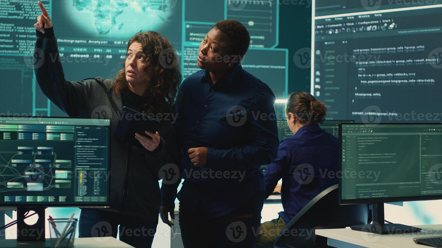 Cyber security experts women working on spyware and malware detection in a governmental agency. Examining server information on a big screen to combat cyberterrorism and cyberwarfare. Camera A. photo