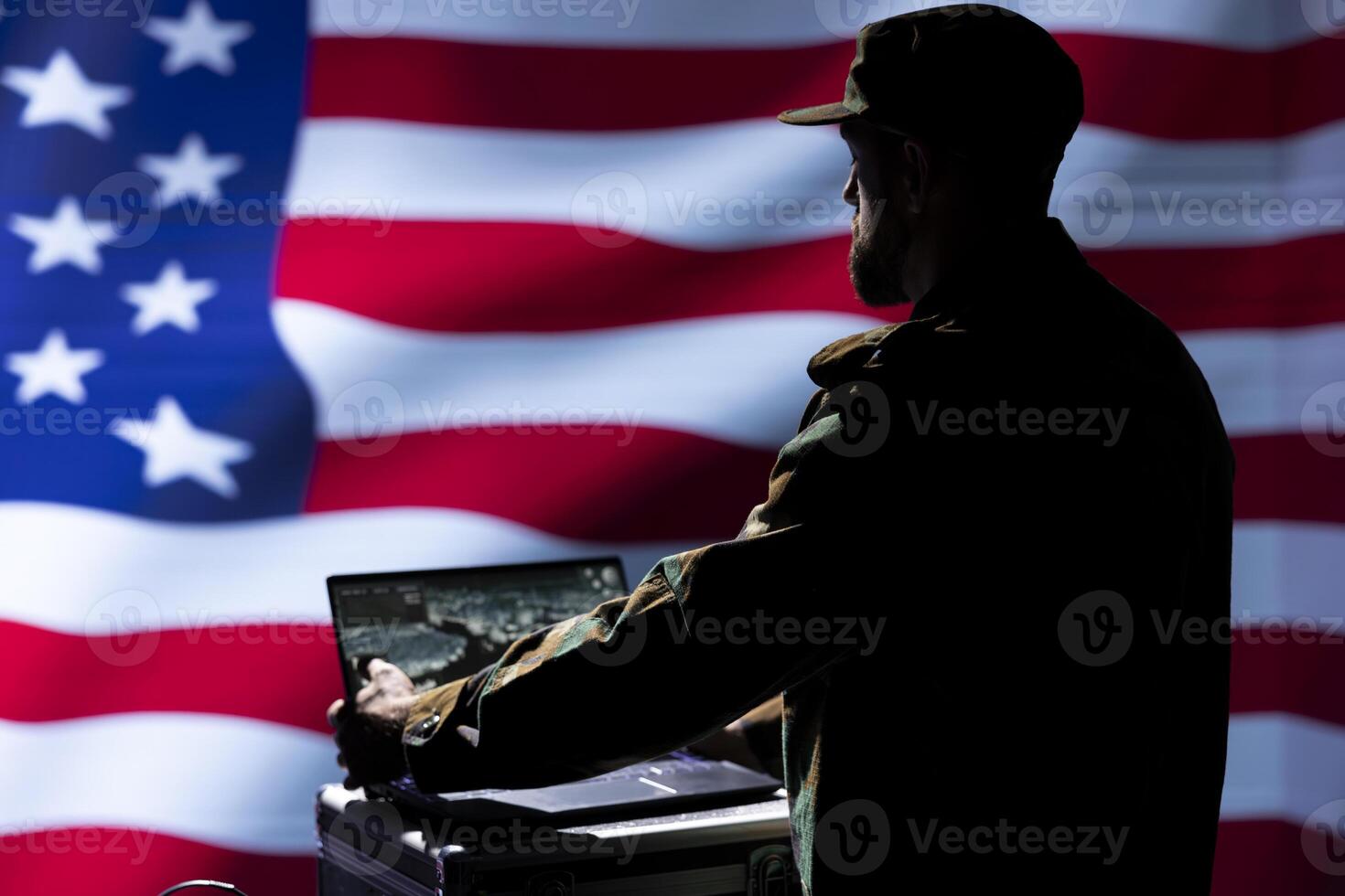 American army operative conducts tactical reconnaissance, utilizing laptop for data analysis and mission planning. US Air Force agent looking at aerial map on screen, pinpointing targets photo