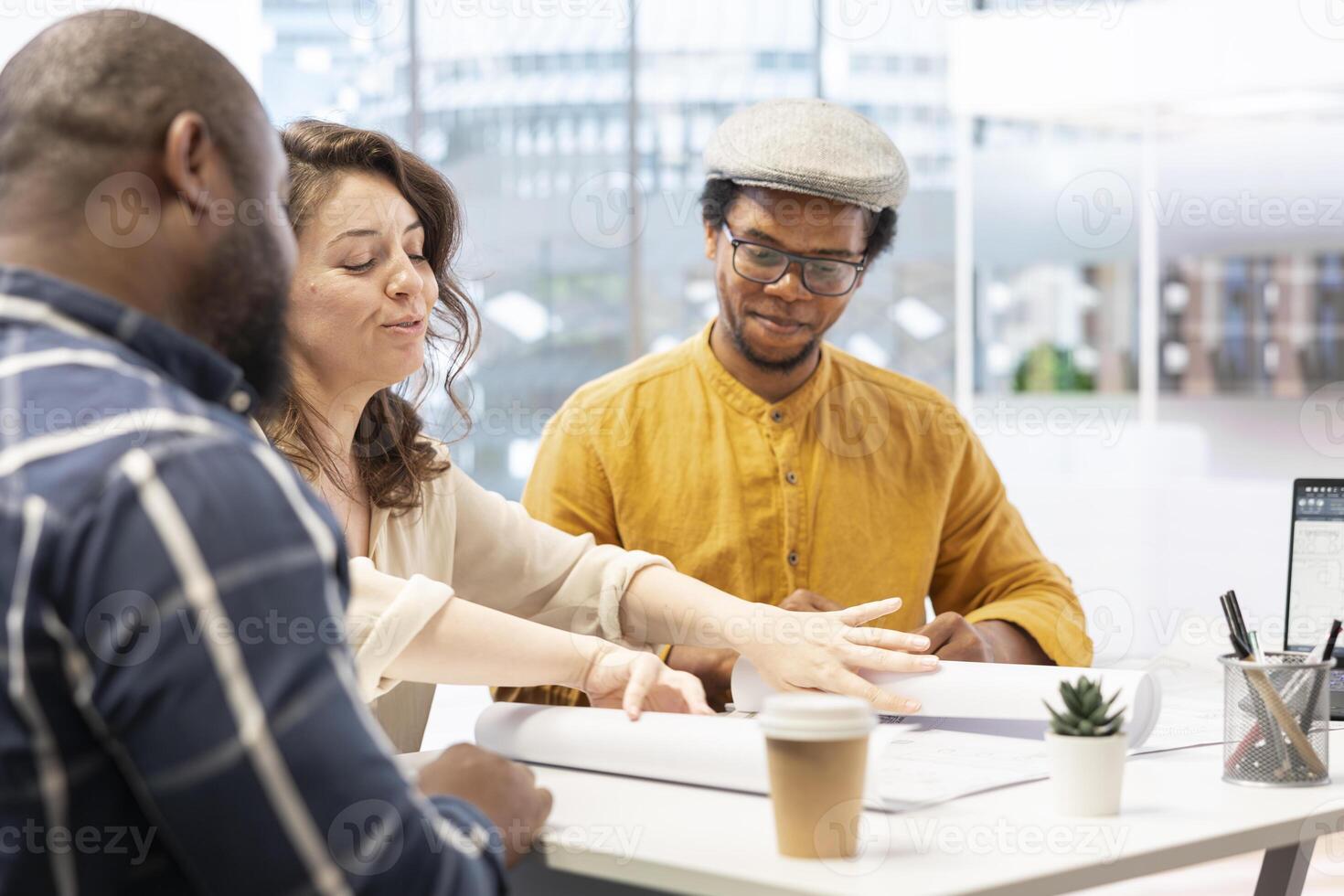 Real estate agent providing layout blueprints to clients in evaluating investment opportunity for leasing a new office space. Business team negotiating with realtor, contract agreement. photo