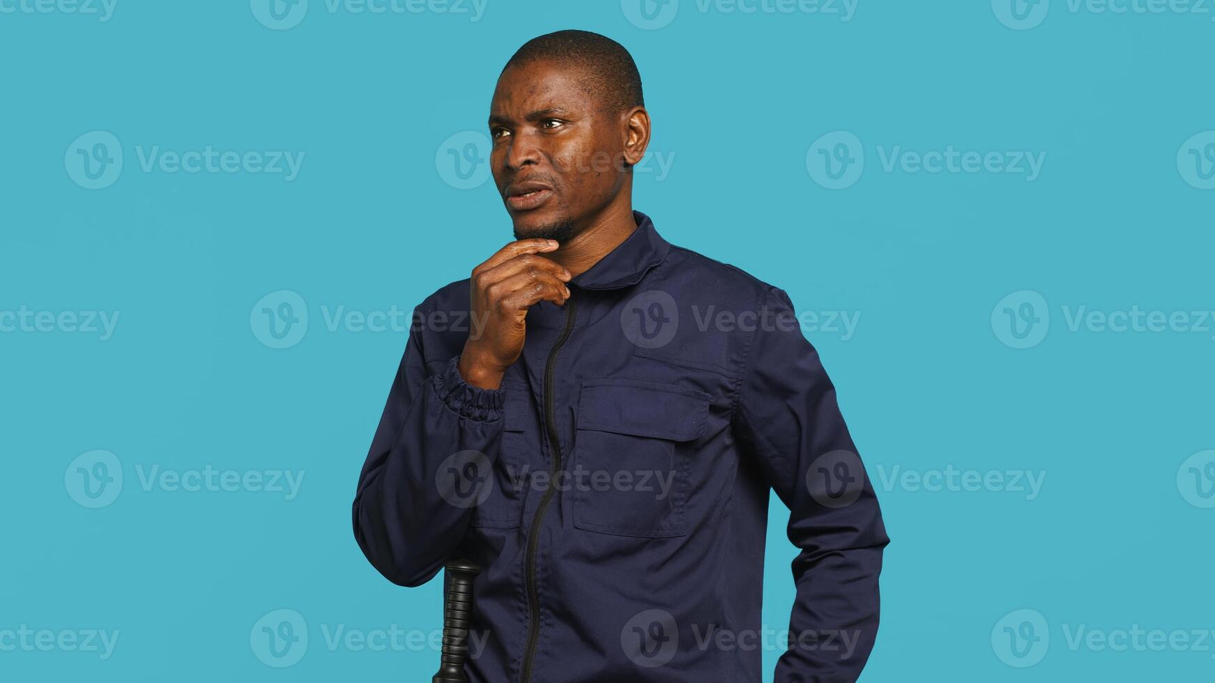 Portrait of security guard using notepad to take notes of suspicious activity while overseeing premises. Private law enforcement worker documenting security protocols, studio backdrop, camera A photo