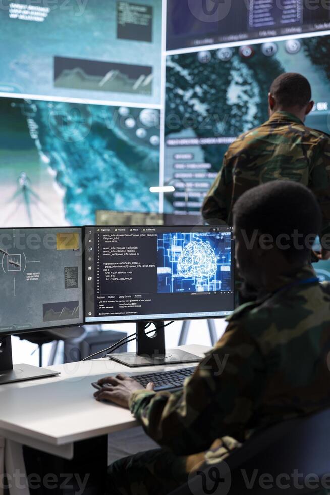 Military experts in a mission control center use modern technology on computer and big screen, analyzing satellite footage and data. Specialist tracking potential threats for intelligence operations. photo