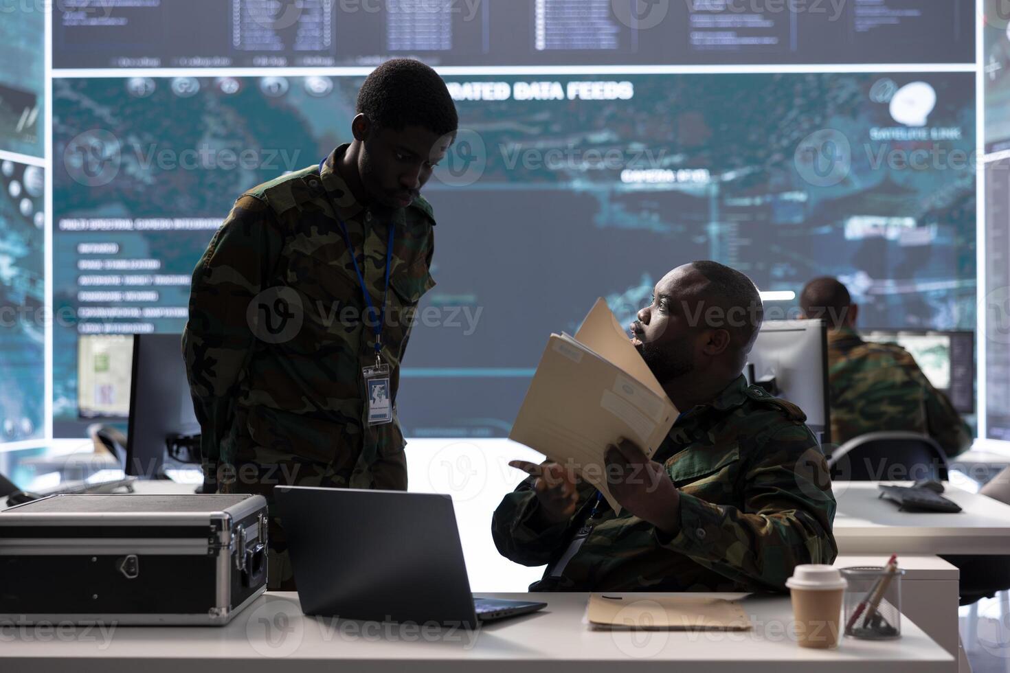 Army specialist in a control center manages satellite real time data, overseeing live surveillance footage for reconnaissance activity. Intelligence operations to support national defense mission. photo