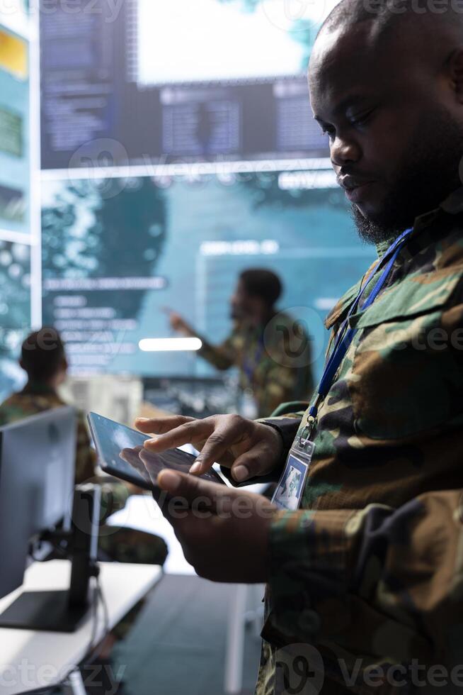 Military personnel in a command post working on data processing, integrating real time surveillance and maintaining security protocols essential for strategic defense mission. Secret service. photo