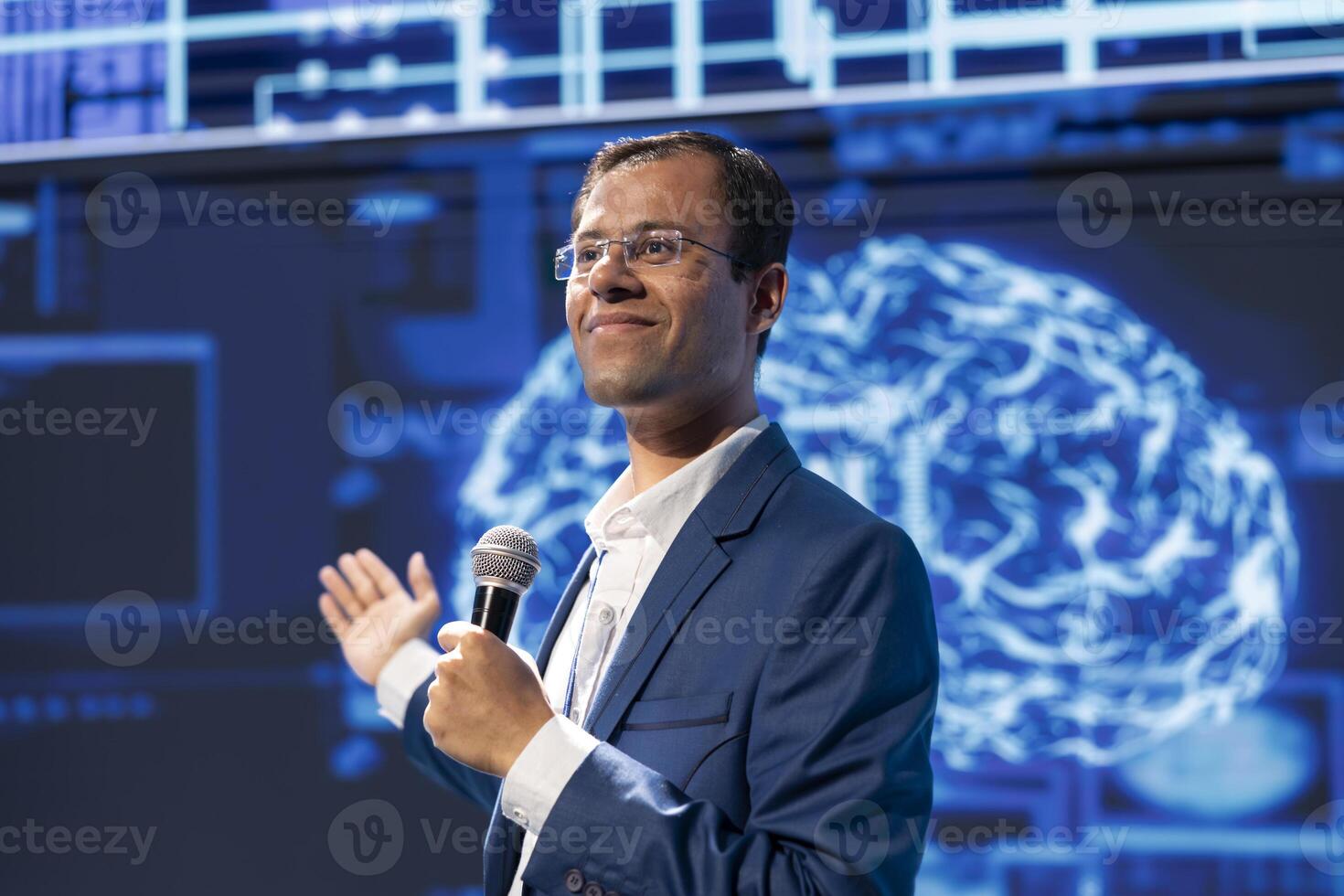 Smiling speaker speaking at tech conference, exploring latest AI technology trends and case studies. Happy IT specialist presenting how artificial intelligence is shaping future during event photo
