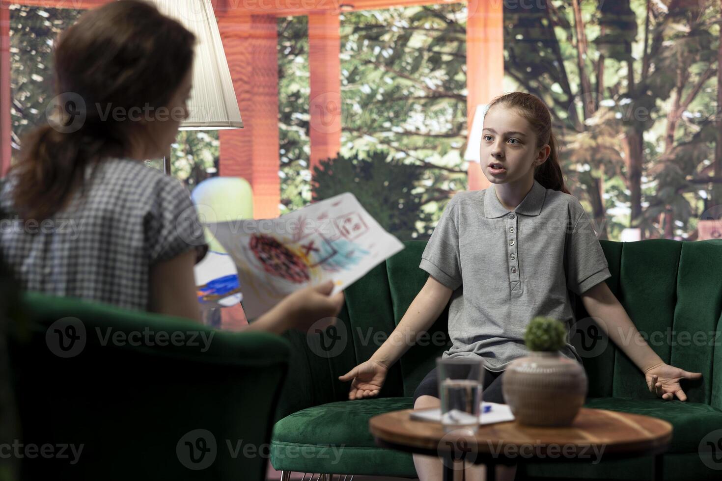 Young girl getting angry at psychologist when reviewing disturbing drawings, showing signs of murder deviant behavior. Teenager with social problems and anger management issues. photo