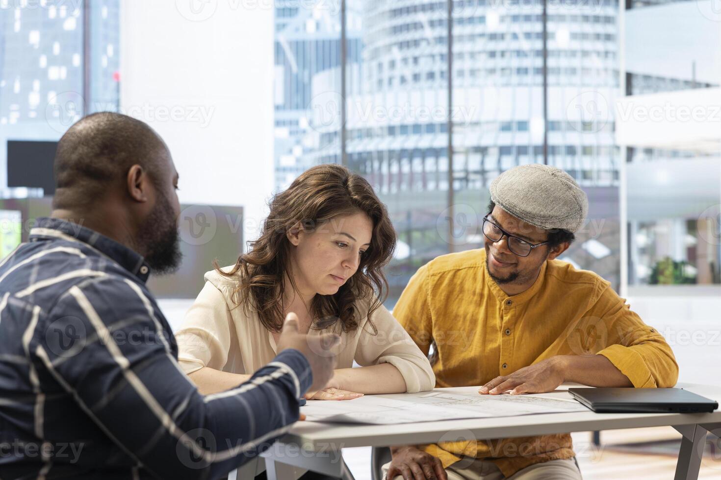 Real estate agent presenting the property investment opportunity available from leasing the new high class office space. Realtor evaluating blueprints and building layouts at desk. photo