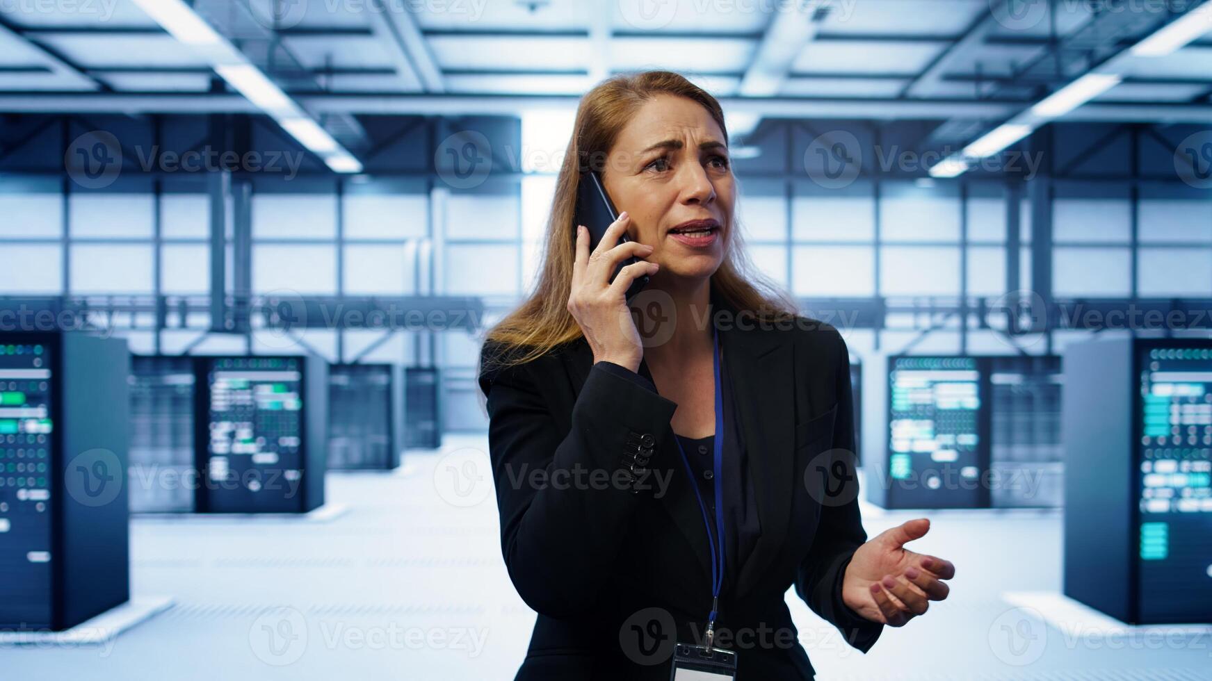 Technician in data center talking in phone call, doing yearly inspection. On field system administrator talking with manager in server hub during telephone call, monitoring servers, camera B photo