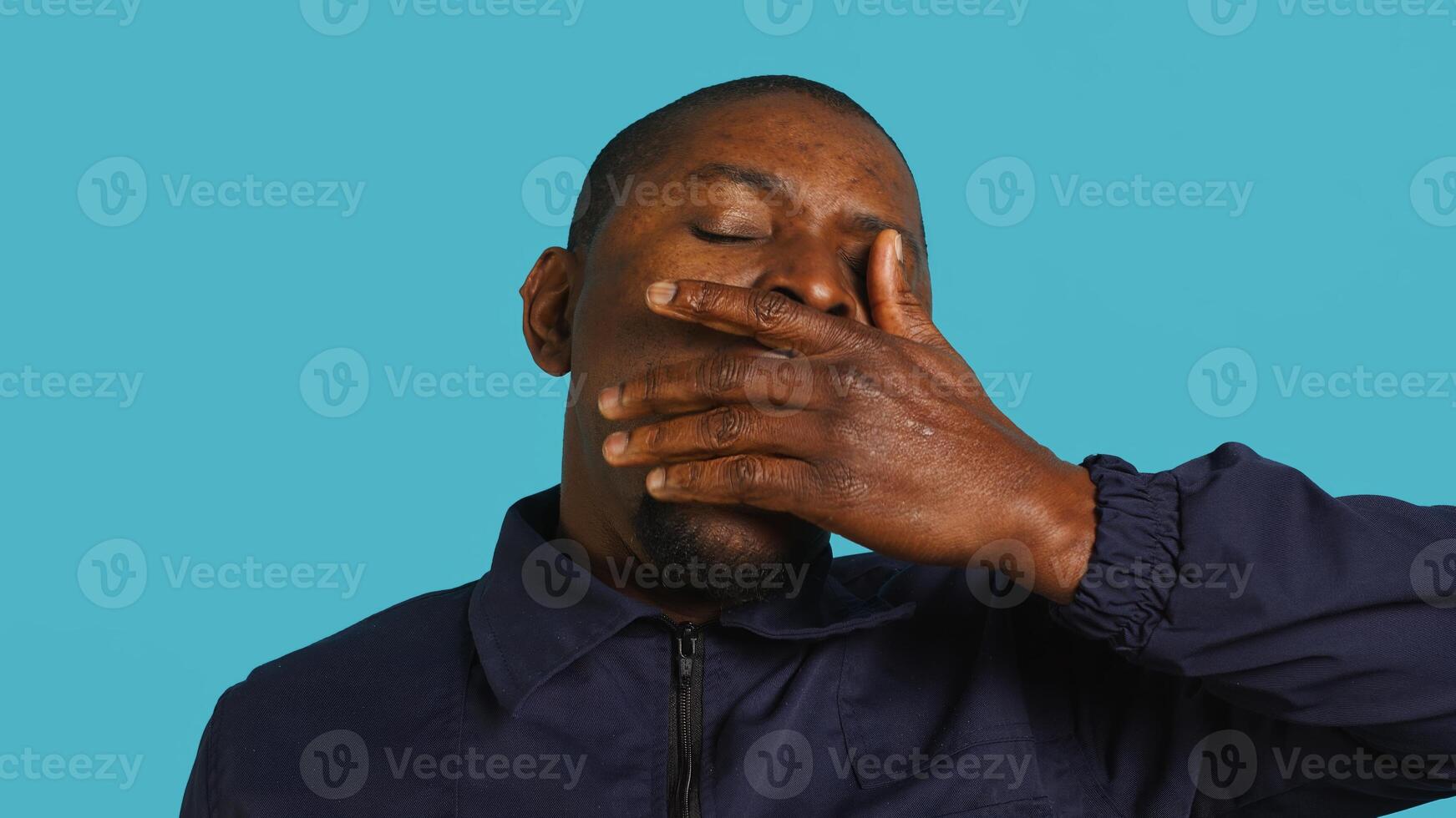 Portrait of security job employee yawning while at work detaining perpetrators, feeling tired. Patrol guard feeling exhausted after long night shift, isolated over studio background, camera A photo