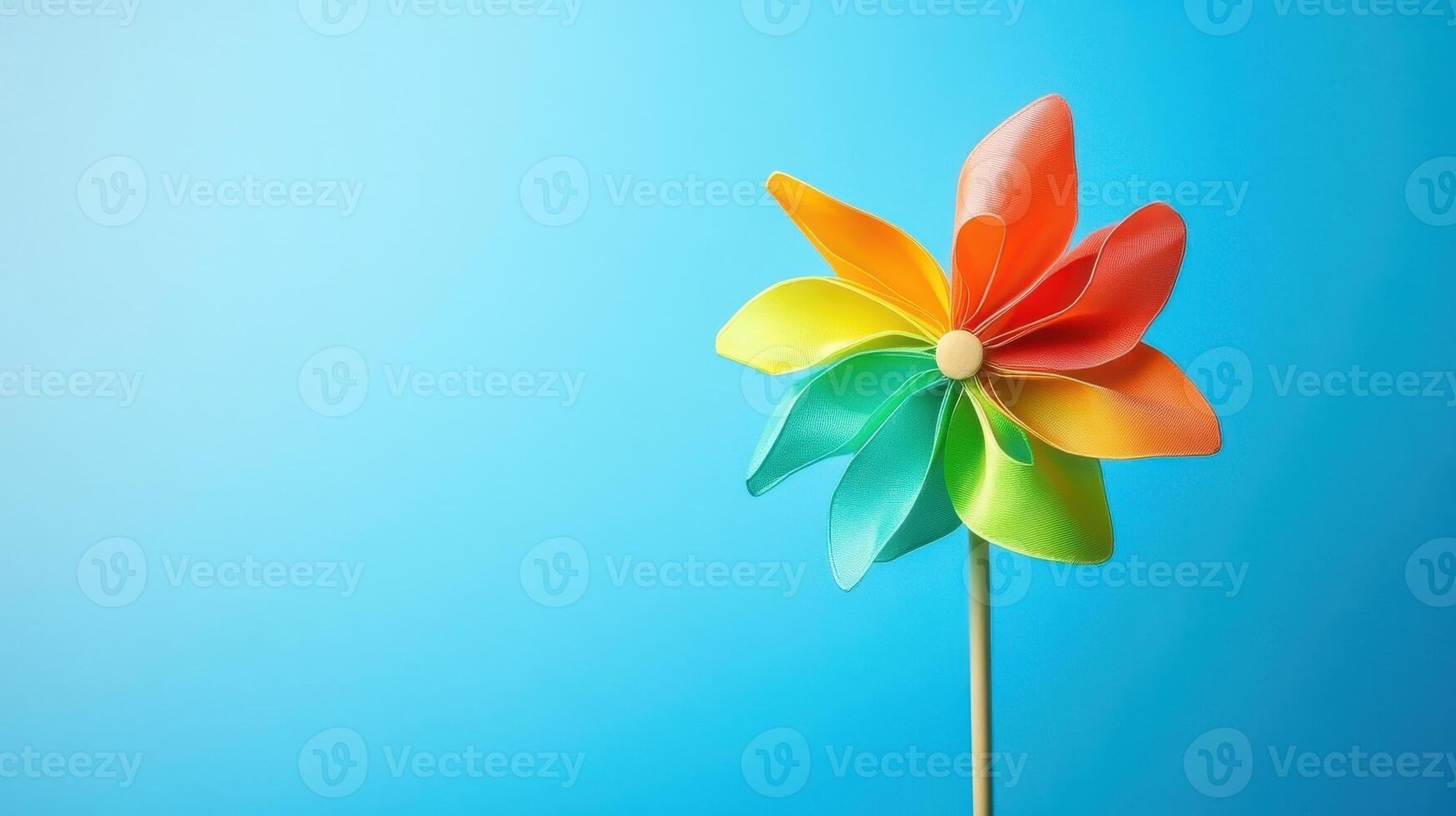 Colorful pinwheel spins gently against a bright blue background in a cheerful display of childhood nostalgia and fun photo