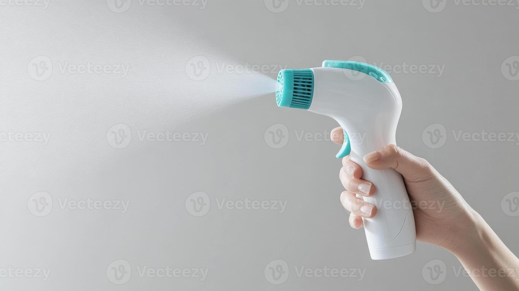 Handheld spray device releasing mist for moisturizing or cleaning purposes in a neutral setting photo