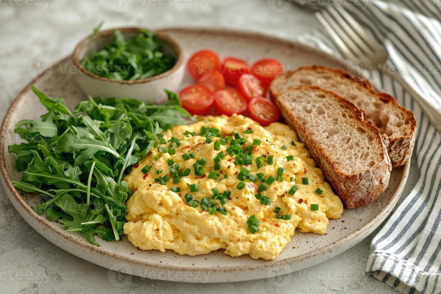 Scrambled eggs with cherry tomatoes, arugula and bread photo