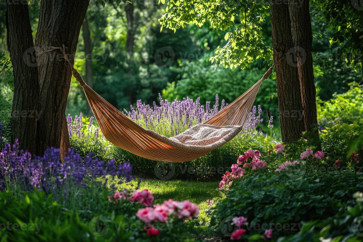 Hammock hanging between trees in peaceful blooming garden. photo