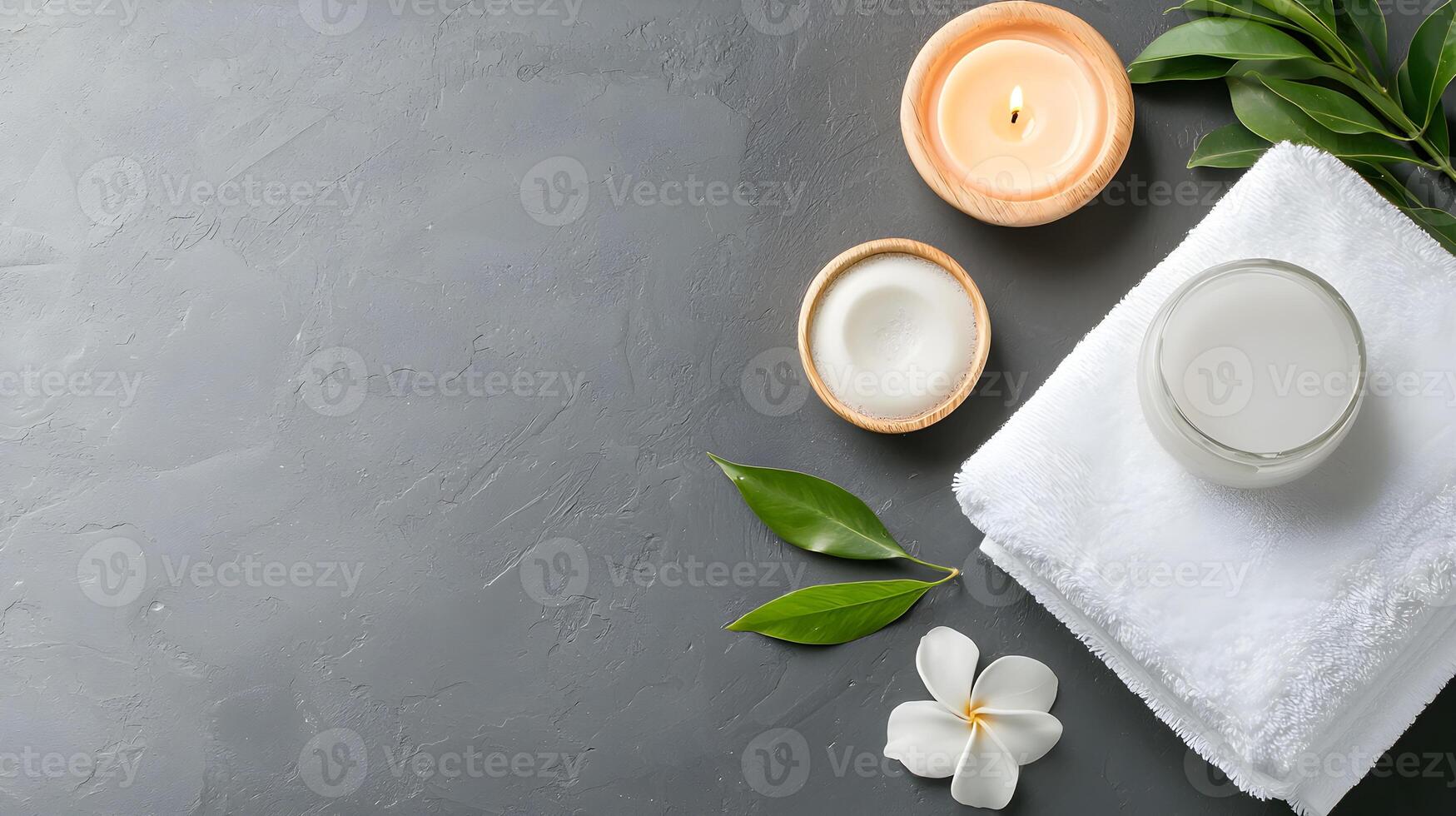 Relaxing Spa Setup with Candles, Cream, Towel and Green Leaves photo