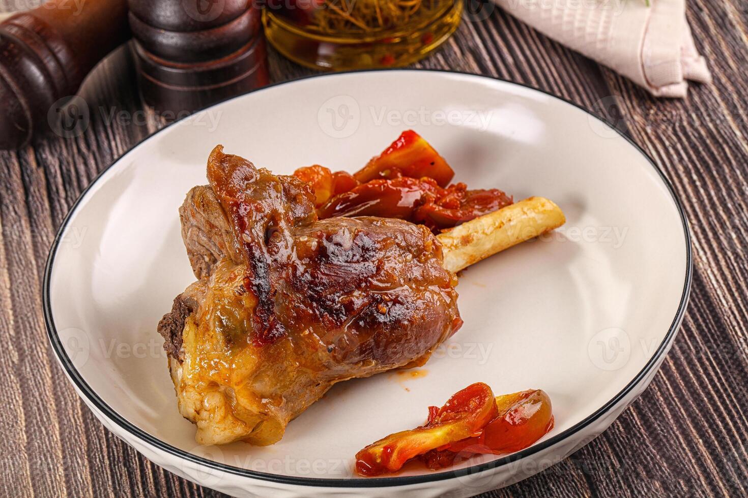 Baked lamb shank with vegetables photo