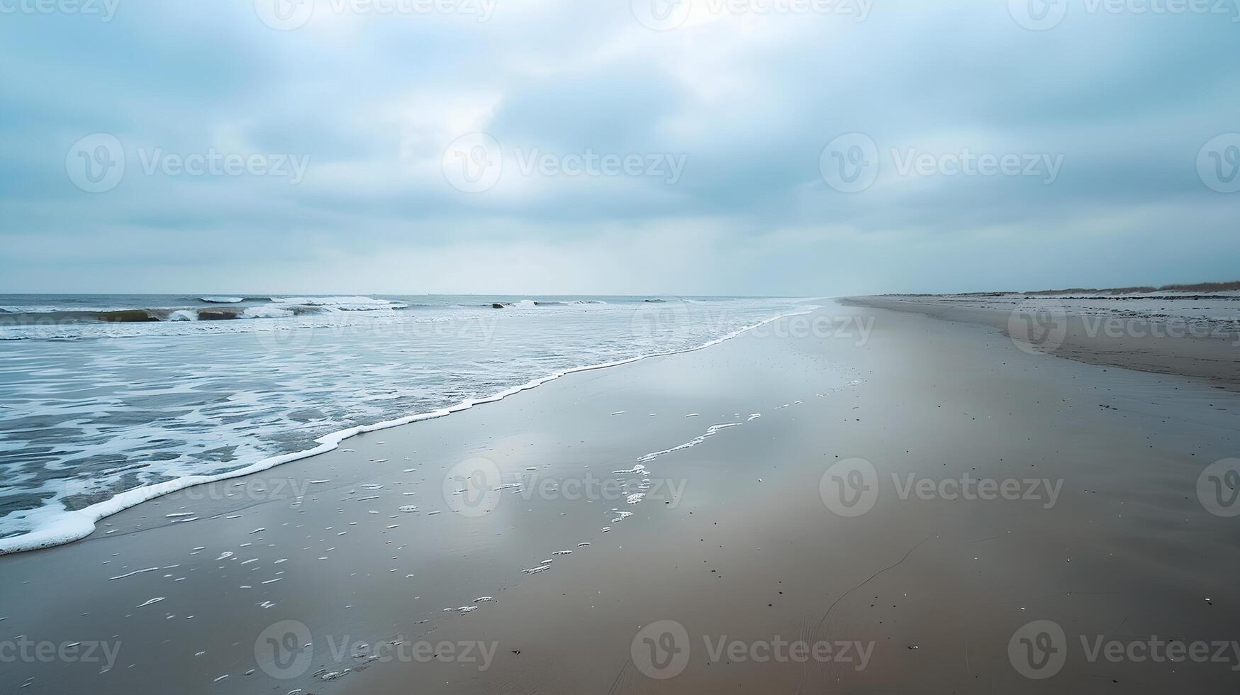 Calm Beach Scene with Overcast Sky and Gentle Waves photo
