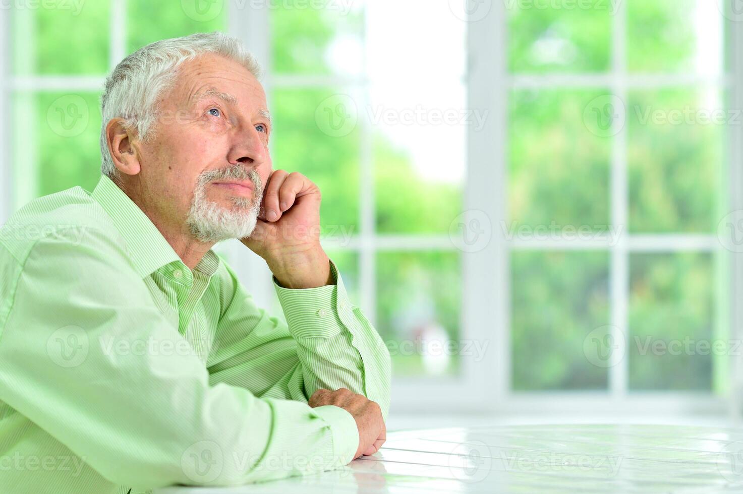close-up portrait of a senior man thinking about something photo