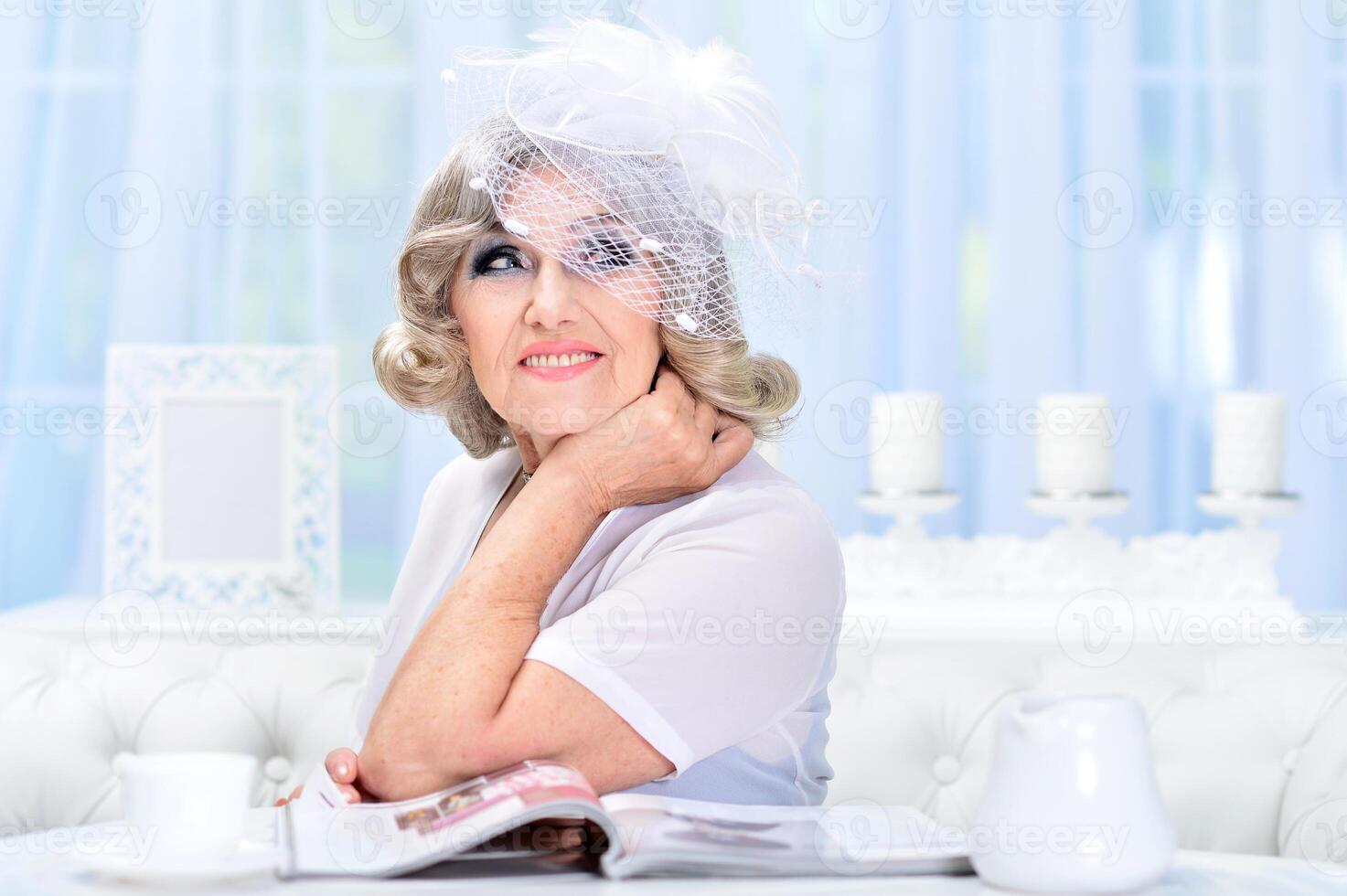 Portrait of happy senior woman posing at home photo