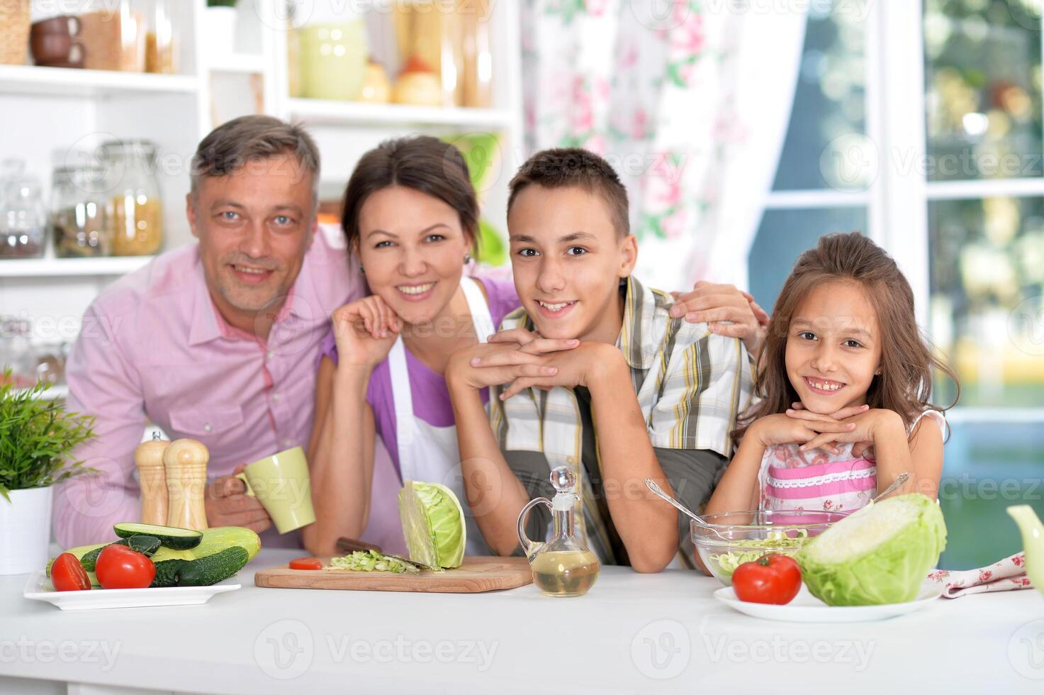 Portrait of beautiful family cooking at kitchen photo