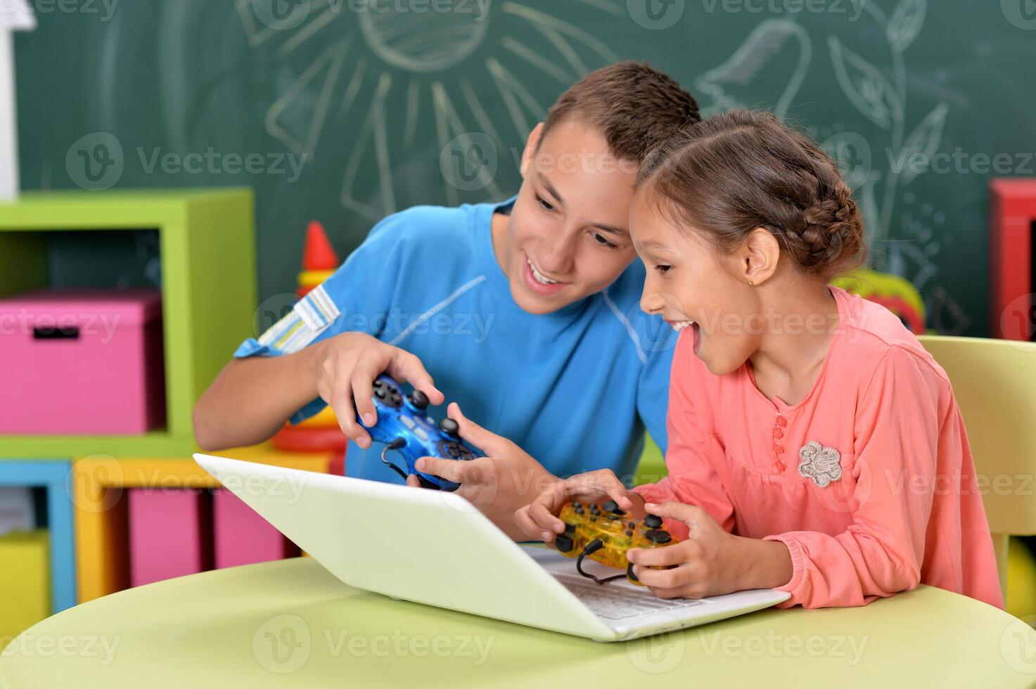 Portrait of brother and sister using laptop photo