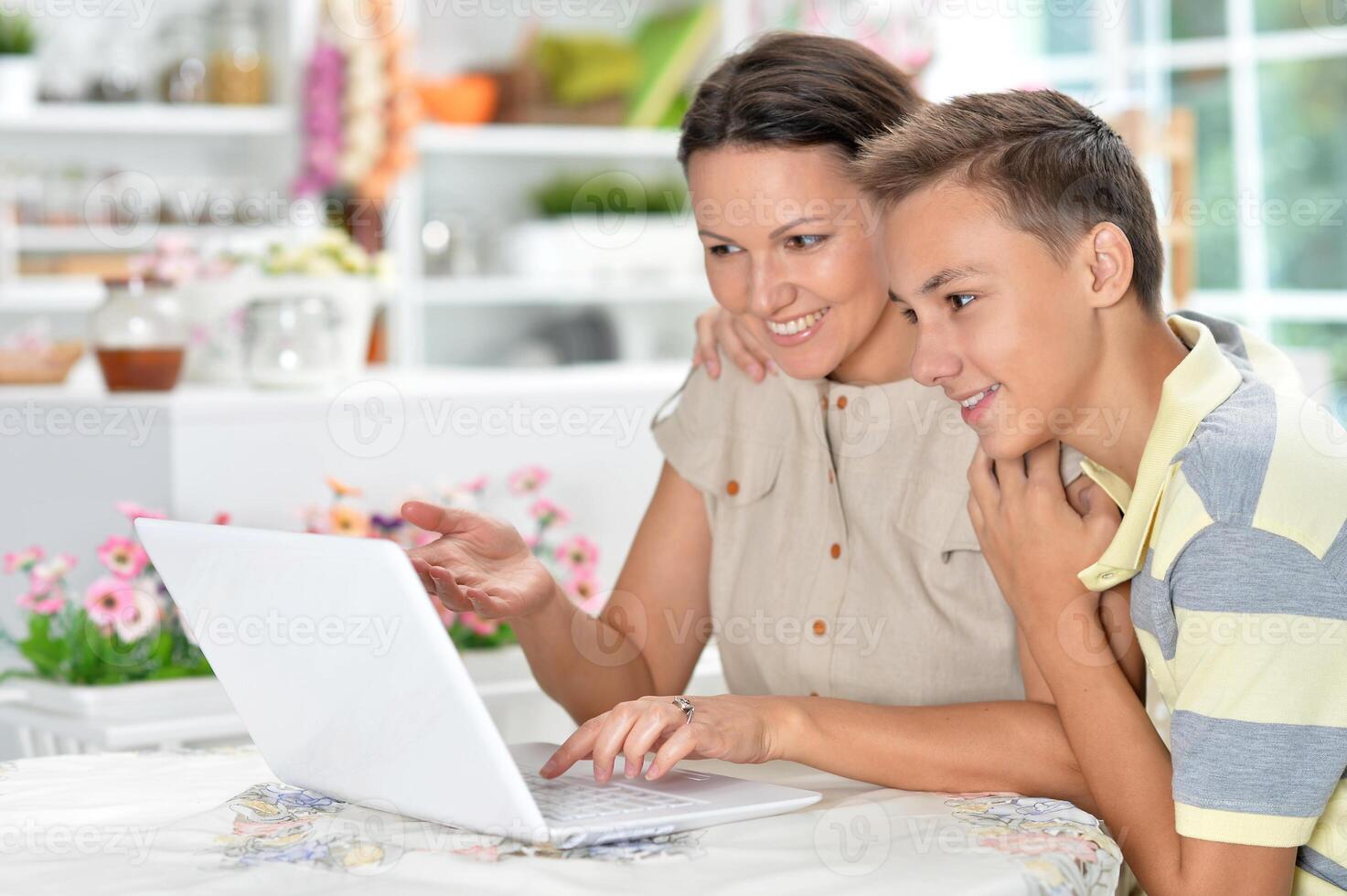 Close up portrait of mother and son using modern laptop photo