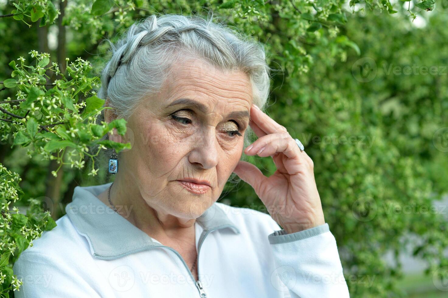 Portrait of senior sad woman in park photo