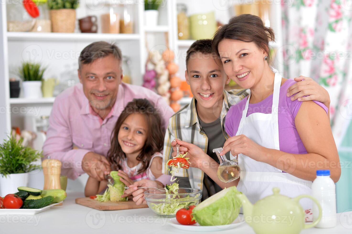 Portrait of beautiful family cooking at kitchen photo