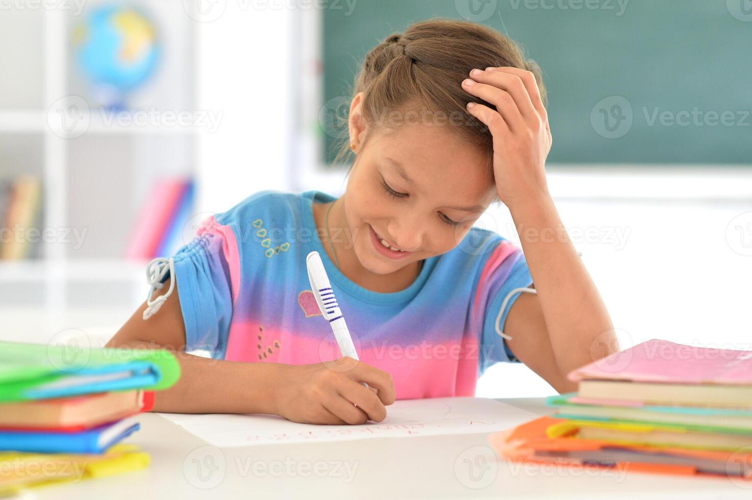 Portrait of girl studing with books at classroom photo