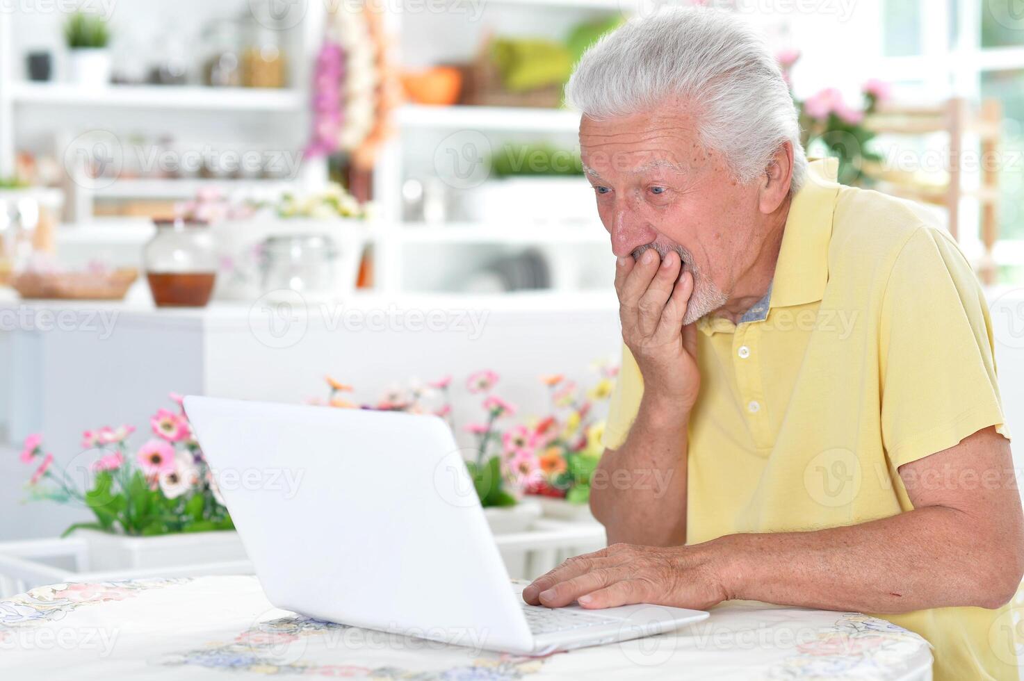 Portrait of senior man with laptop at home photo