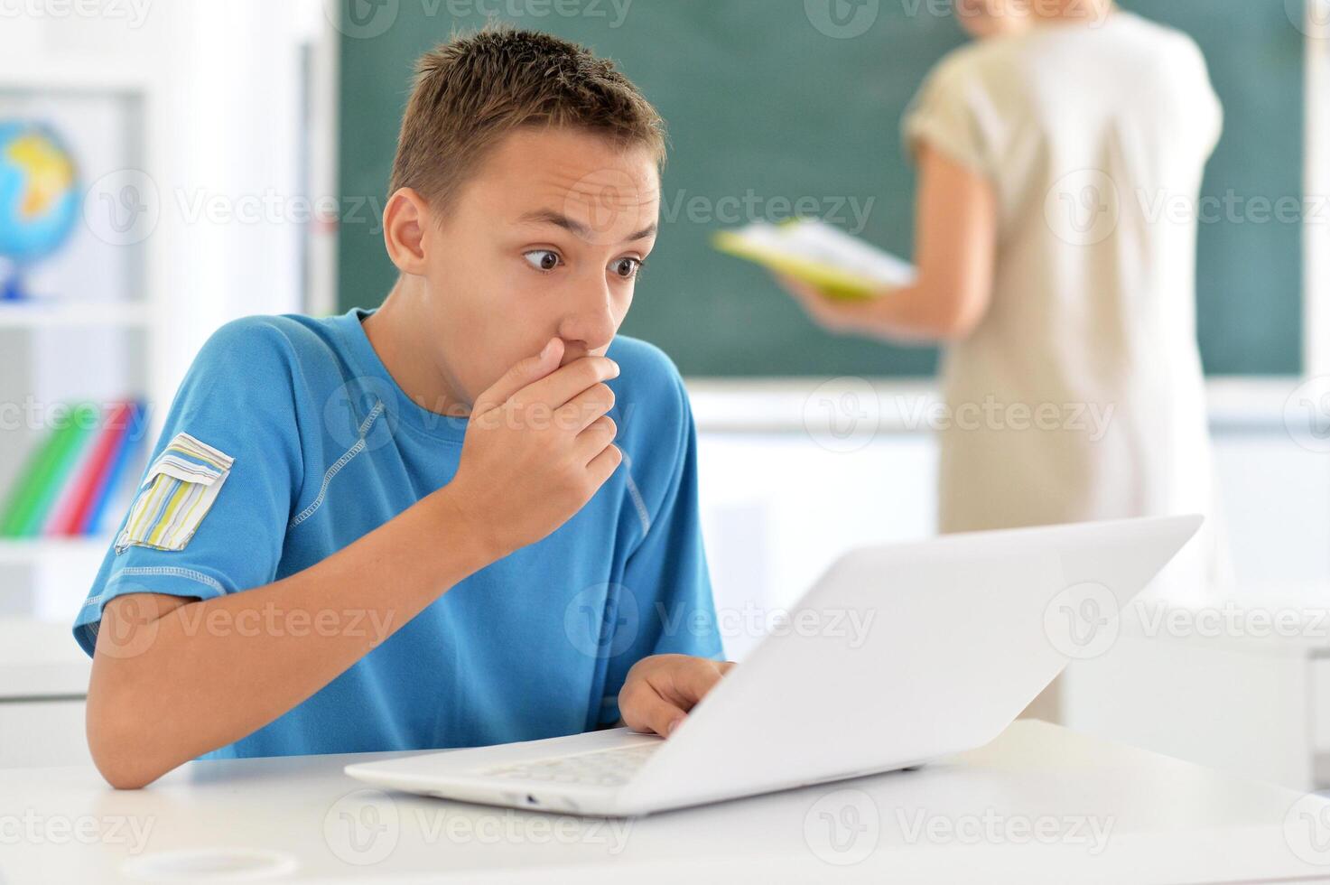 Portrait of boy studing with laptop at classroom photo