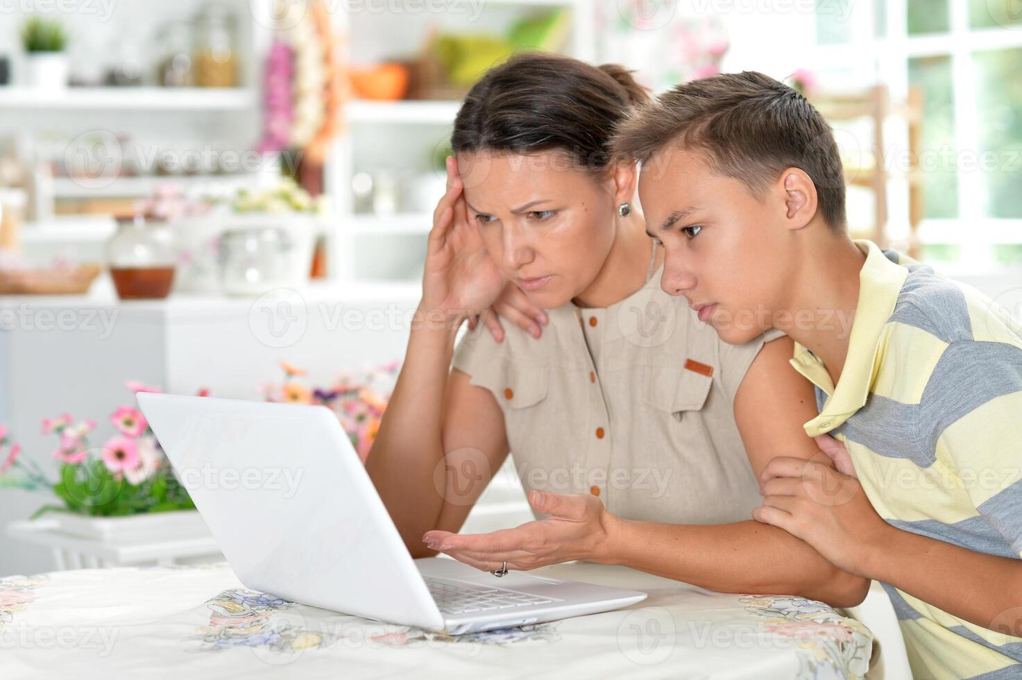 Close up portrait of mother and son using modern laptop photo