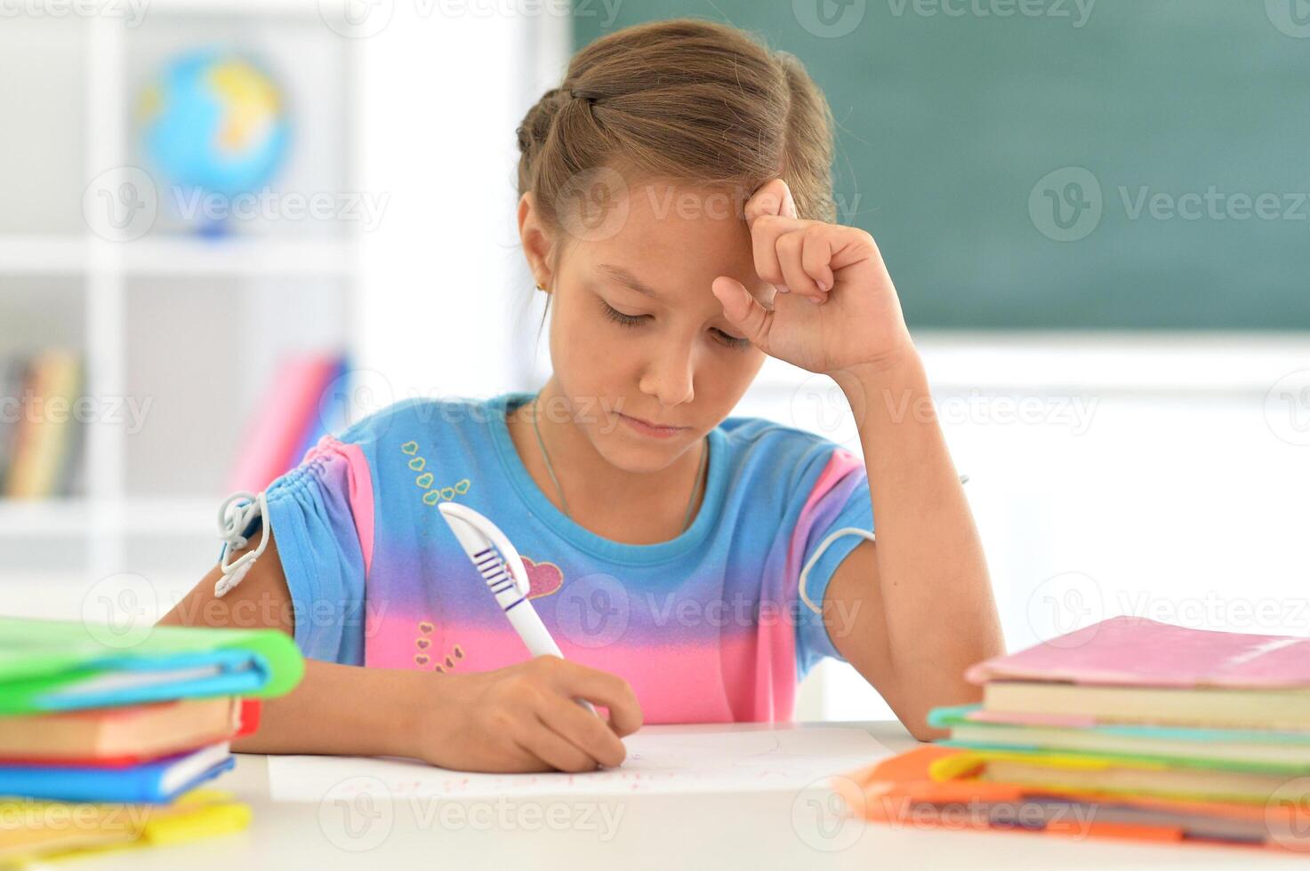 Portrait of girl studing with books at classroom photo