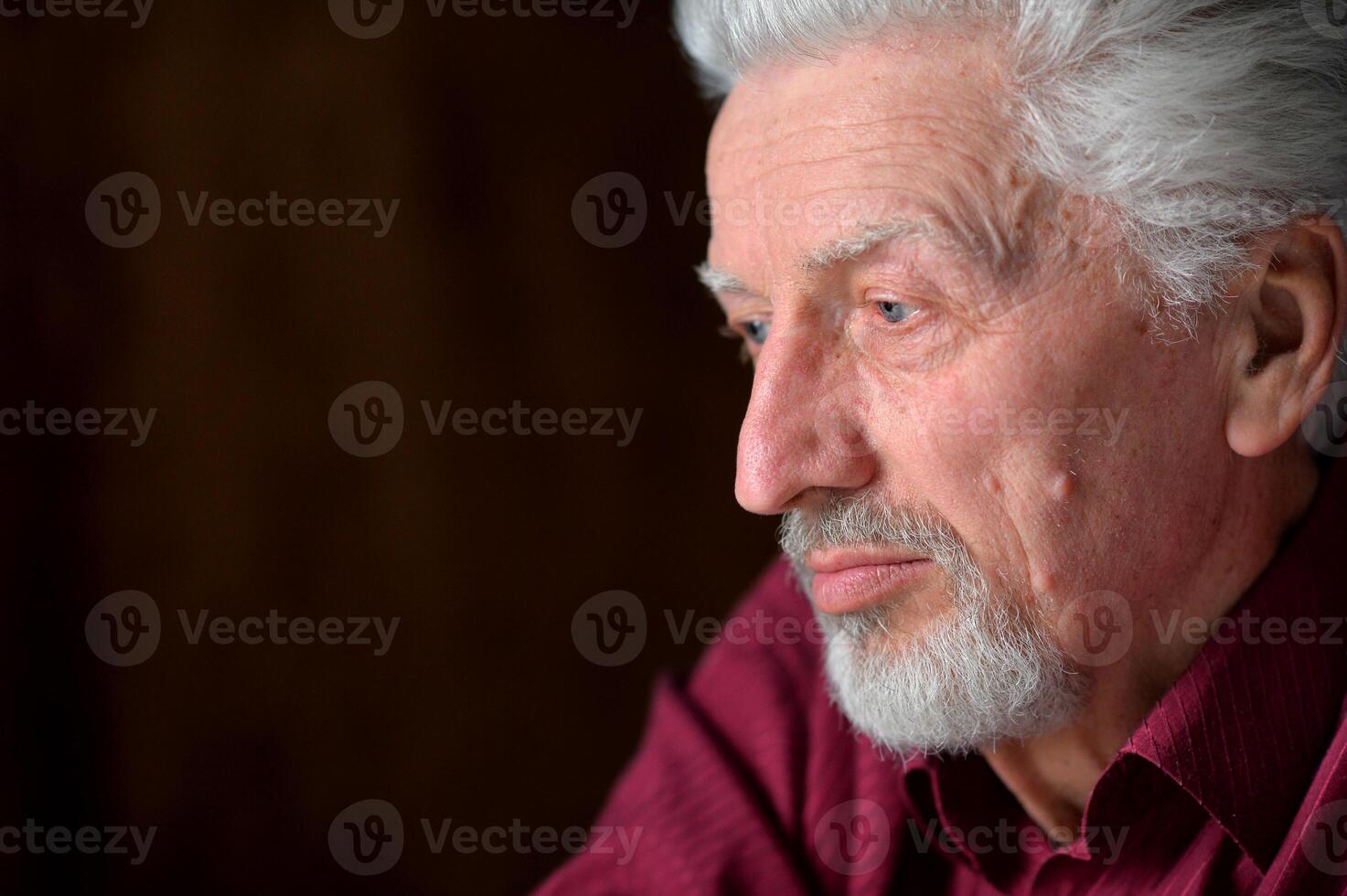 close-up portrait of a senior man thinking about something photo