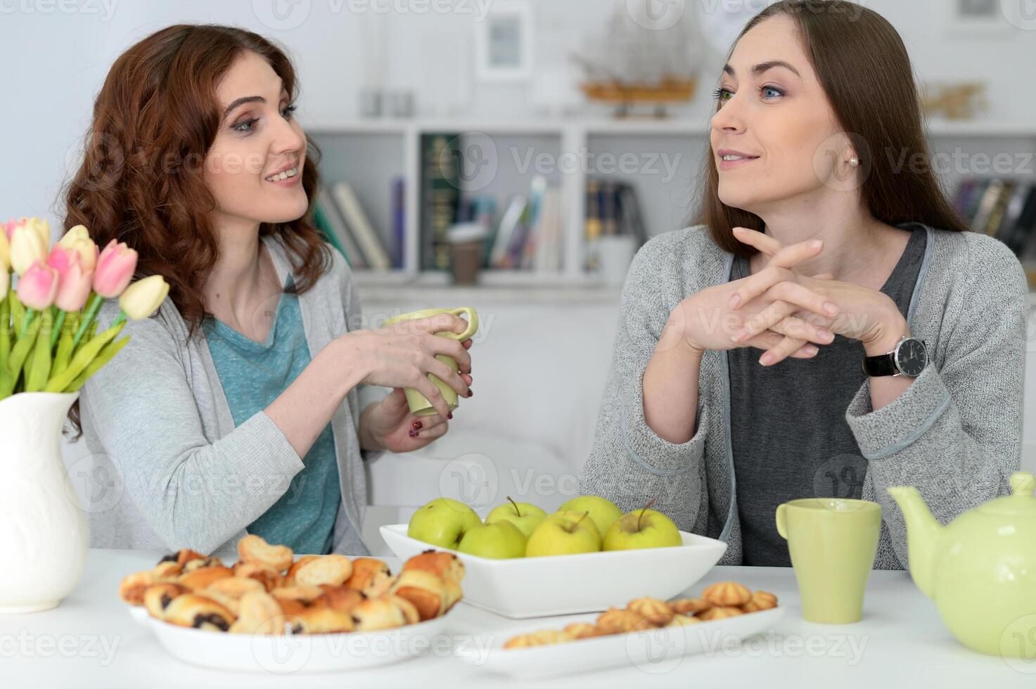 Two best friends eating while sitting at the table together photo