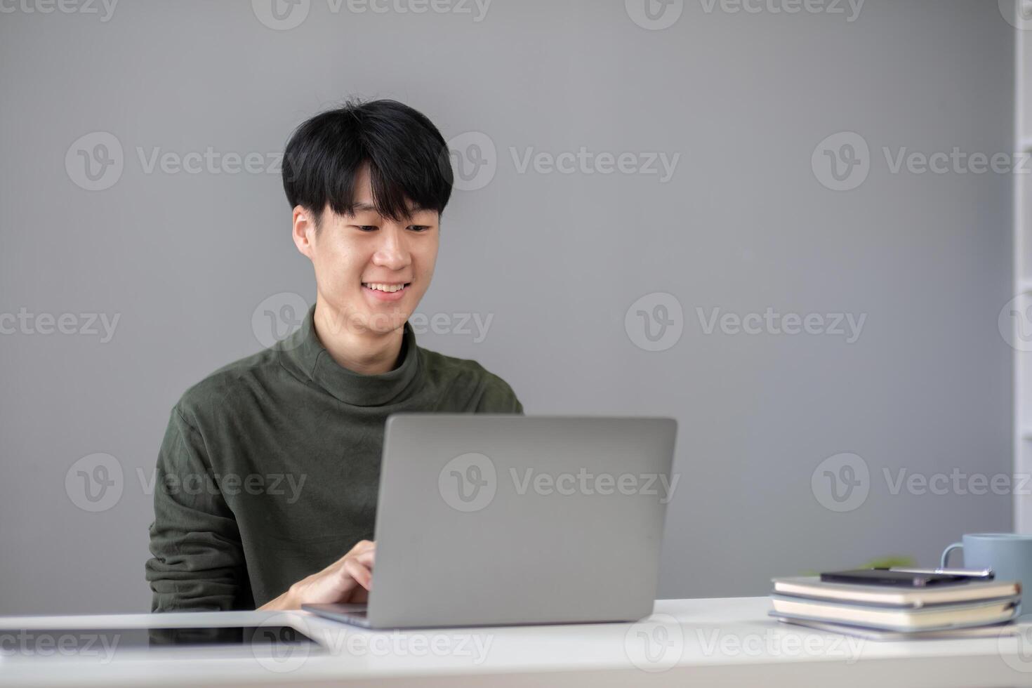 Portrait of a handsome young office worker intently studying how to do a presentation project on a laptop in his office. photo